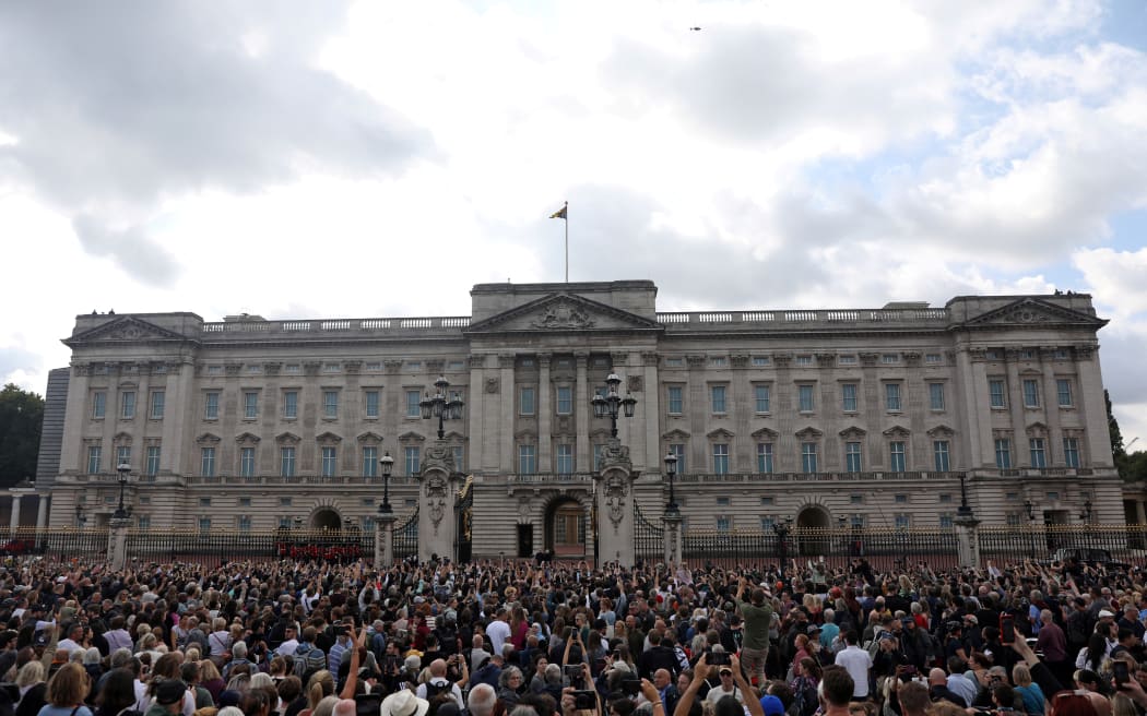 King Charles III and Camilla, Queen Consort (C) walk into Buckingham Palace after greeting the crowd and looking at floral tributes, in London, a day after Queen Elizabeth II died.