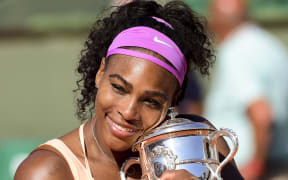 The world number one American Serena Williams clutches the 2015 French Open trophy.