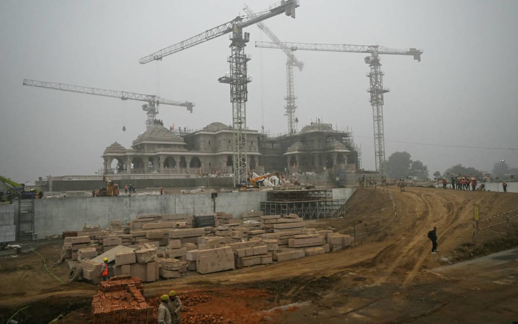 Security personnel stand guard at the construction site of a temple to Hindu deity Ram, in Ayodhya on December 29, 2023. (Photo by Arun SANKAR / AFP)