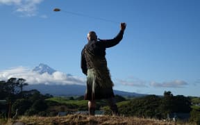 Rangi Kipa swings a purehua at Parihaka  to gather the spirits ahead of the Crown's arrival for the apology.