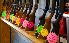 Rifles standing upright in rack with flouro price tags