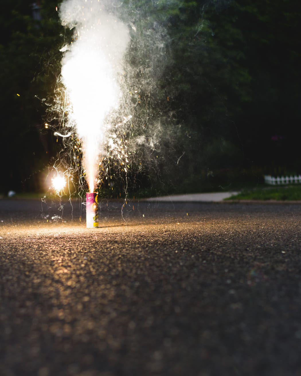 A small firework is set off on a street.