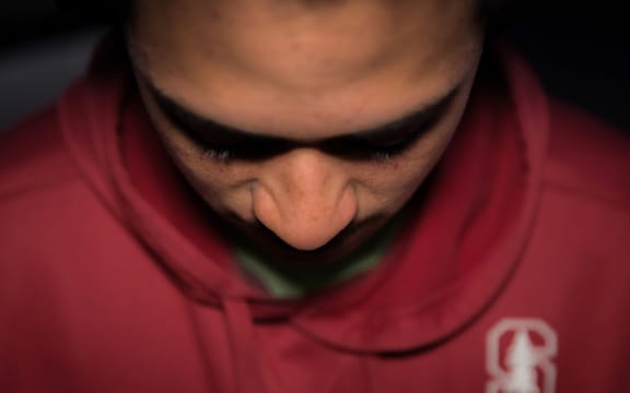 A teenage Māori boy looking unhappy