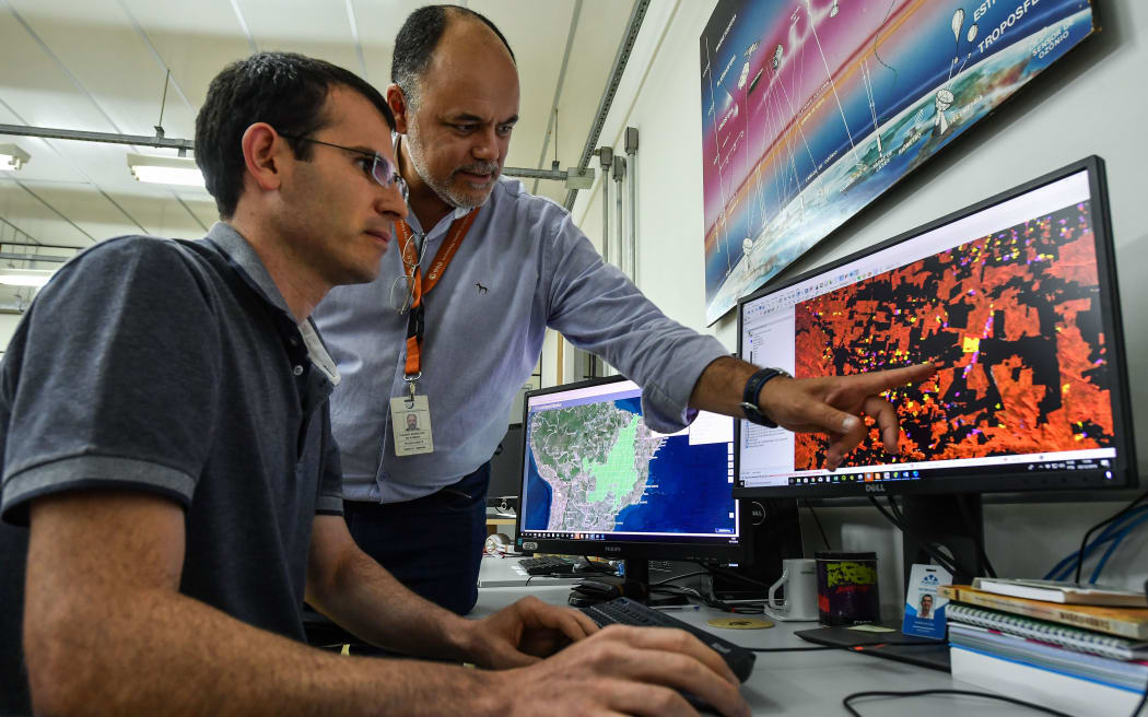 Brazilian coordinator of the Amazon Program, Claudio Almeida, speaks with a researcher at the National Institute for Space Research (INPE) headquarters, in Sao Jose dos Campos.