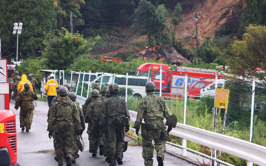 Members of Japan Self-Defense Force head for a landslide site amid pouring rain in Gamagori City, Aichi Prefecture on August 28, 2024. The landslide occurred at a two-story wooden house on the night of Aug. 27th, and a family of five trapped. One of them, a woman in her 40s, was rescued, but the remaining four are believed to be inside collapsed houses. According to the Nagoya Regional Meteorological Observatory, 138.5 mm of rain fell in Gamagori City between the time it began raining at 4 p.m. on Aug. 26th and 11 p.m. on Aug. 27th, exceeding the average amount for the entire month of August.( The Yomiuri Shimbun ) (Photo by Koji Ito / Yomiuri / The Yomiuri Shimbun via AFP)