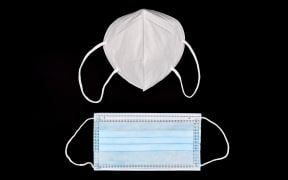 Disposable KN-95 mask vs thin surgical mask. COVID-19 prevention. H1N1, H5N1 safety measures. Isolated on black background.