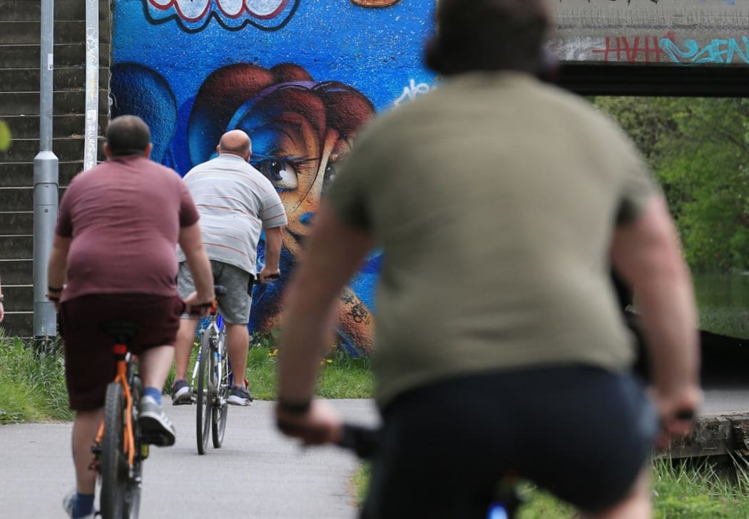 People take their daily exercise along the Leeds to Liverpool canal in Leeds, northern England on May 2, 2020, during the nationwide lockdown to curb the novel coronavirus COVID-19 pandemic.