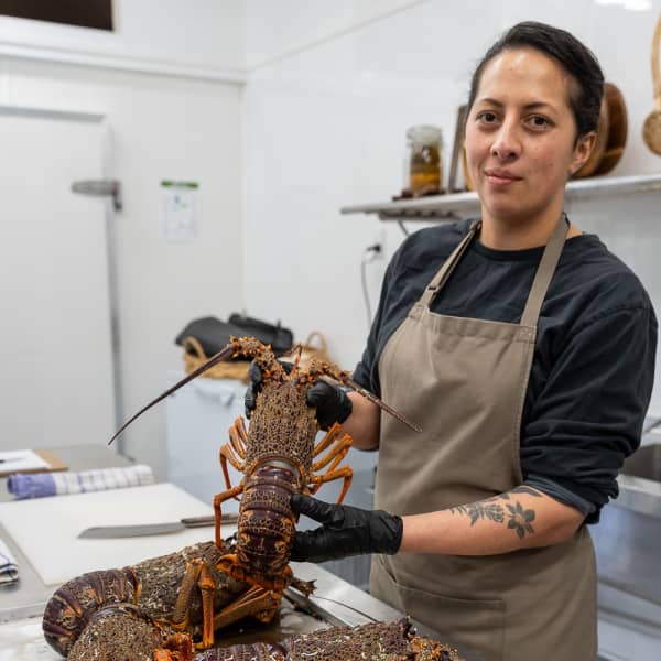 Monique Fiso holds a kōura (crayfish) in an episode of the TVNZ show Hui Hunters.