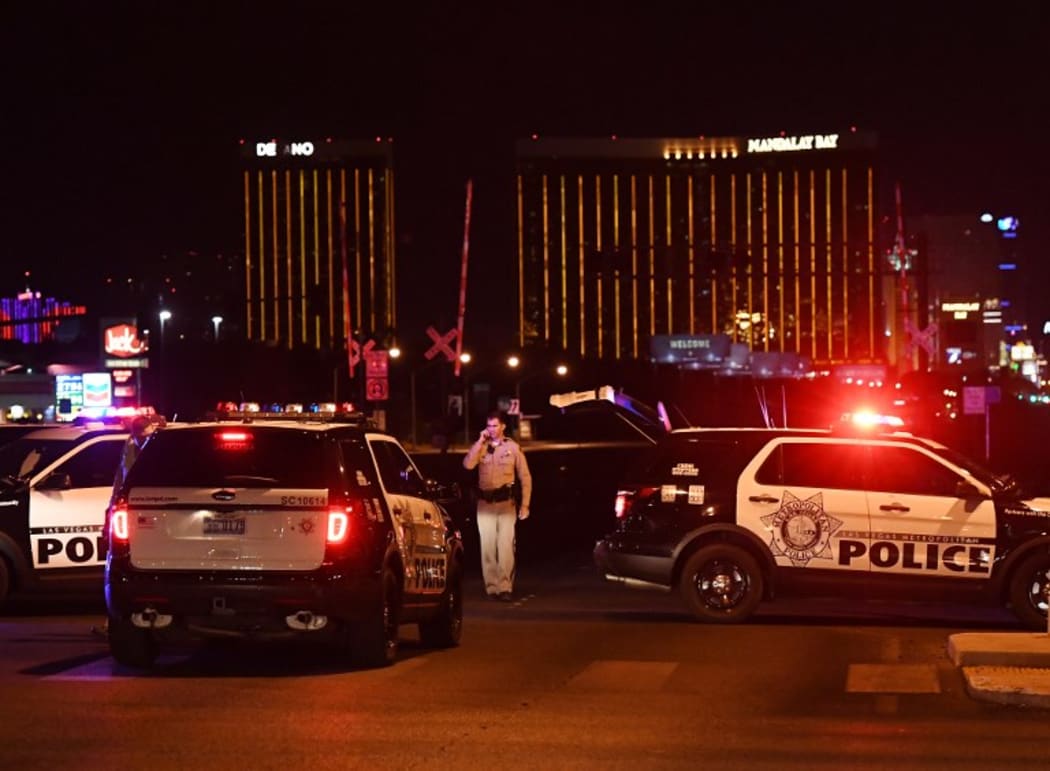 Police form a perimeter around the road leading to the Mandalay Bay hotel.