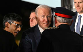 US President Joe Biden (C) reacts as he is greeted by Britain's Prime Minster Rishi Sunak (L) after disembarking from Air Force One upon arrival at Belfast International Airport on April 11, 2023, starting a four day trip to Northern Ireland and Ireland to launch 25th anniversary commemorations of the "Good Friday Agreement" deal that brought peace to Northern Ireland. - US President Joe Biden arrived in Northern Ireland on Tuesday, hoping to help maintain the fragile peace brokered 25 years ago after decades of sectarian violence over British rule. (Photo by Jim WATSON / AFP)