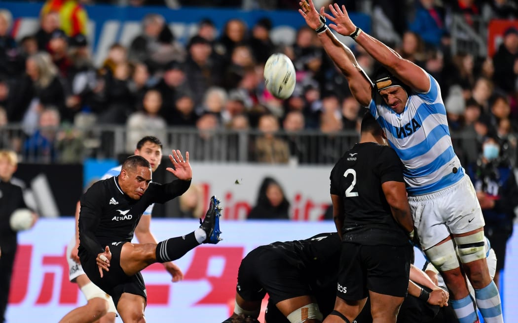 Aaron Smith of the All Blacks kicks under pressure from Tomas Lavanini of Argentina during a Rugby Championship Test in Christchurch.