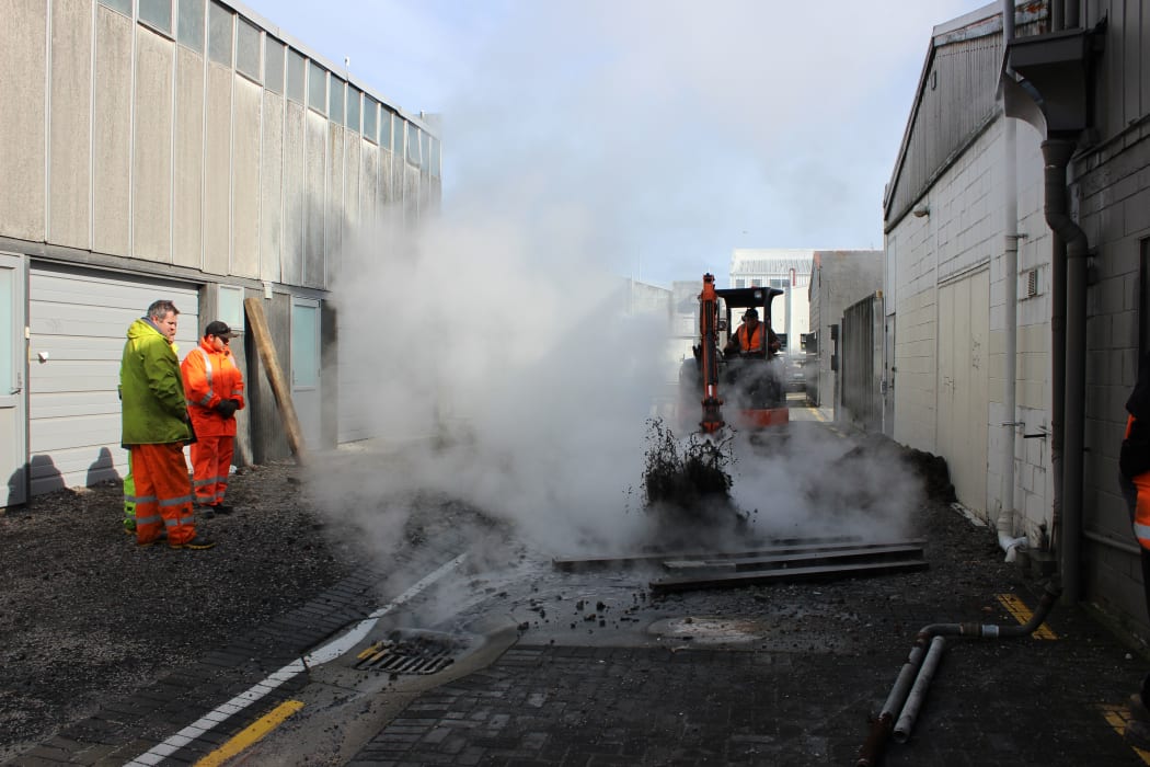 A digger clears the area around the bore, after water has been pumped down it.