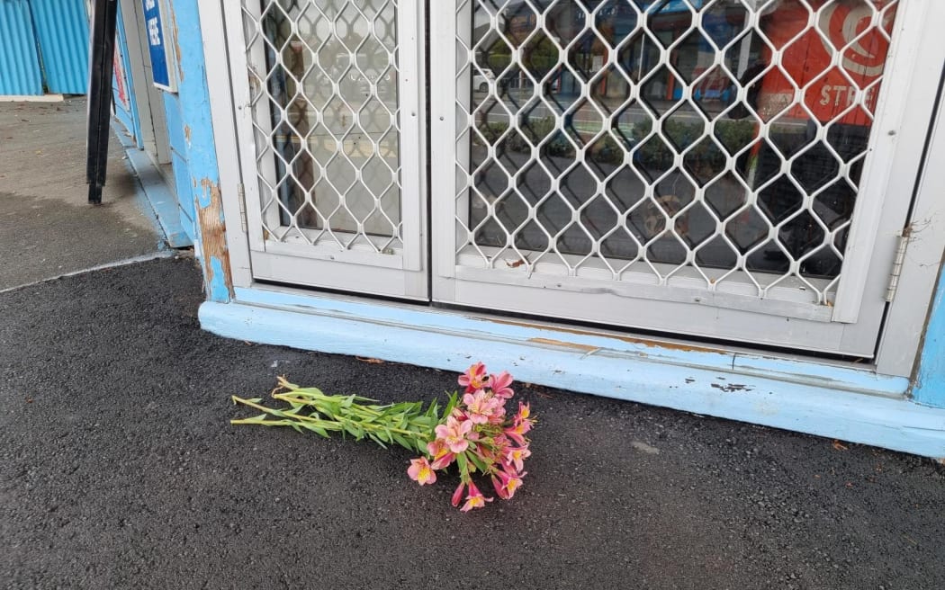 Flowers outside the Opawa Discounter, where the business' owner was stabbed during a robbery on 2 December.