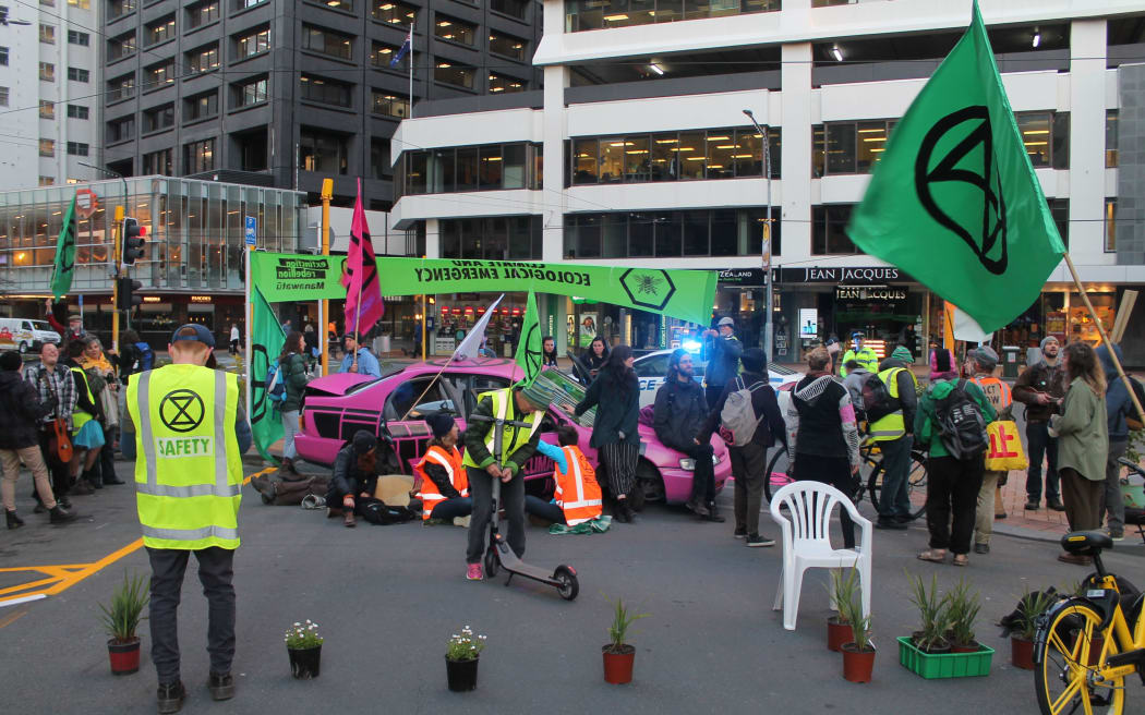 Climate change protesters in Wellington attached to a pink car.