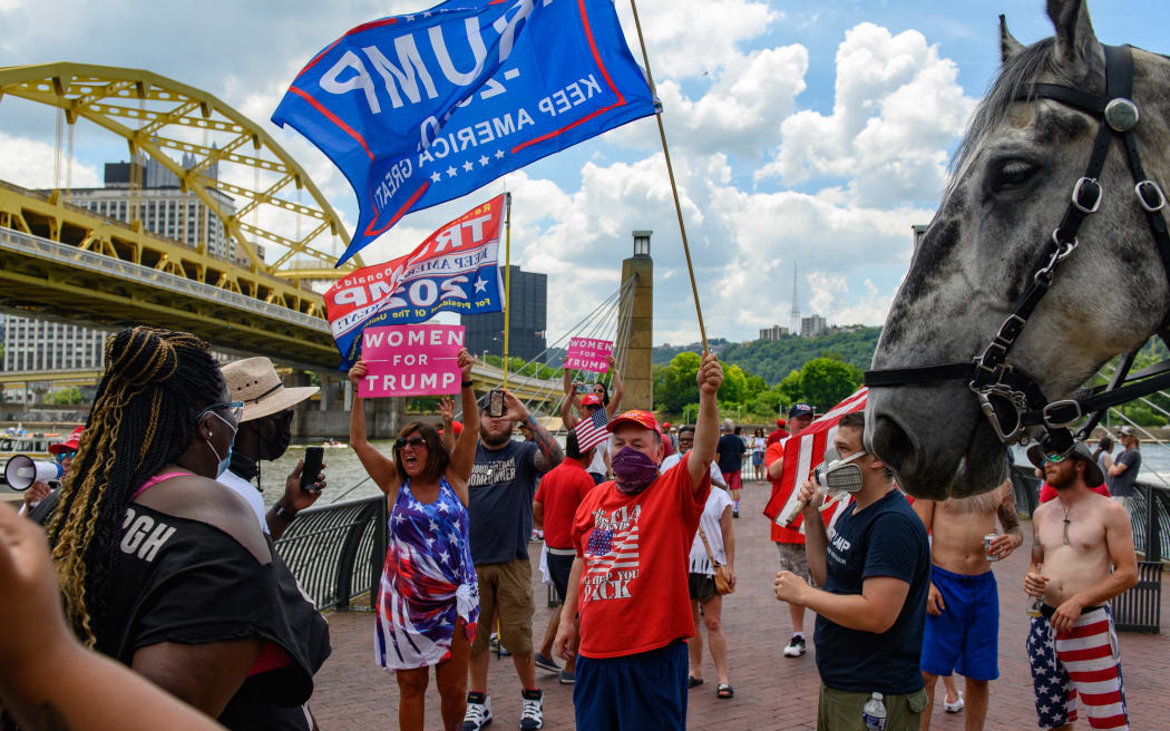 A group of Trump supporters is confronted by a Black Lives Matter protest group while they wait along the Allegheny River North Shore for a flotilla of boats taking part in a boat parade for the re-election of Donald Trump to pass by on 4 July, 2020 in Pittsburgh, Pennsylvania.