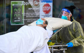 Ambulance officers transfer a resident from the Epping  Gardens aged care facility in the Melbourne suburb of Epping on 28 July 2020.