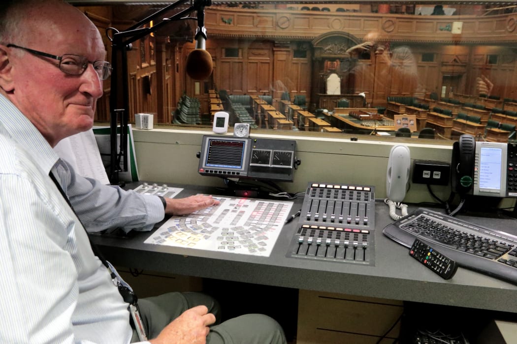 John McGregor poses at the 130 microphone control panel in the  Parliament Audio Booth