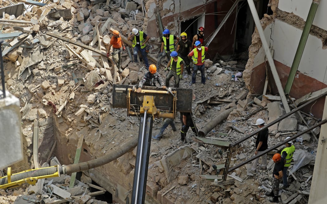 Rescue workers dig through the rubble of a badly damaged building in Lebanon's capital Beirut, in search of possible survivors from a mega-blast at the adjacent port one month ago, after scanners detected a pulse, on September 4, 2020.
