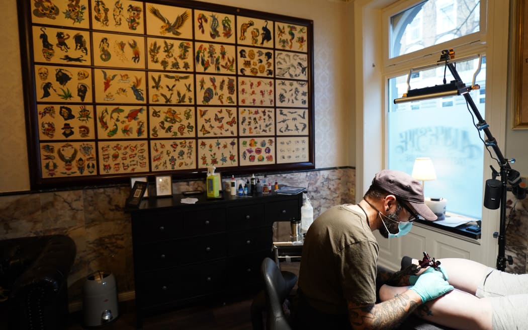 PRODUCTION - 29 November 2021, Hamburg: Tattoo artist Sebastian Makowski works in his tattoo studio "Älteste Tätowierstube in Deutschland" in the St. Pauli district. In January, a ban on colorful tattoo inks comes into force in the EU. (to dpa-Korr "Only doom and gloom? EU regulation threatens colorful tattoo colors") Photo: Marcus Brandt/dpa (Photo by MARCUS BRANDT / DPA / dpa Picture-Alliance via AFP)
