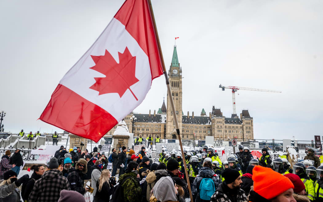 Demonstrators continue their protest in front of Parliament Hill in Ottawa as police deploy to remove them.
