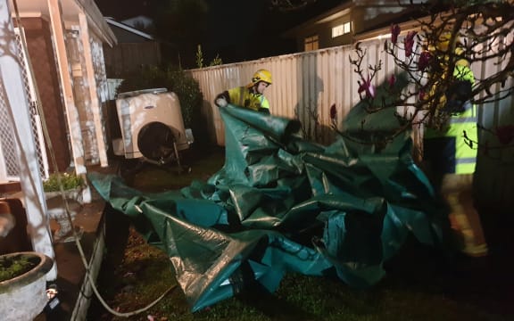 Firefighters securing roofs damaged in the storm.