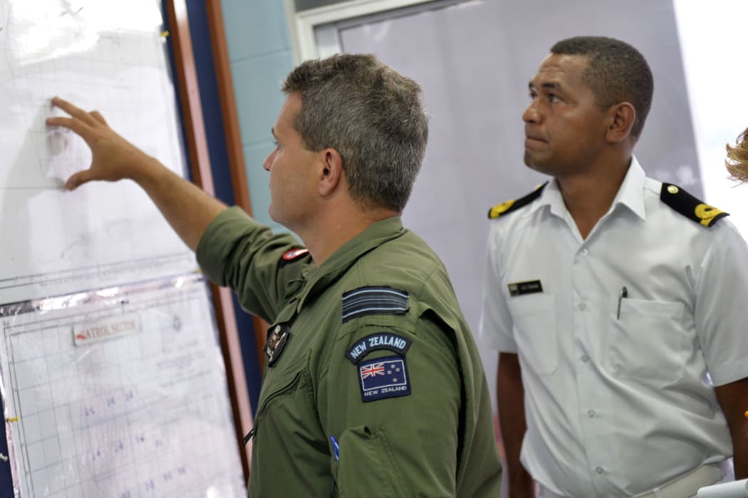 Squadron leader Dale Harlos details the patrol area with Apakuki Tukana of Fiji's Navy.