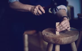 Juliet Arnott knocking in an oak wedge into a greewnwood stool made from ash elm from Hagley Park. Image by Justyn Rebecca Denney