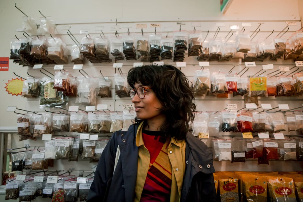 Anique Jayasinghe stands in front of bags of spice in a shop in Whanganui