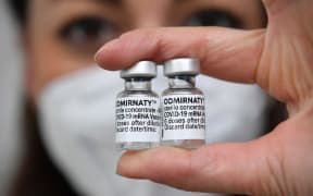 Topic picture - vaccination with the Comirnaty mRNA vaccine from BionTech Pfizer. Vaccine doses with vaccine for injection with a cannula. Close up.
