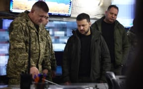 This handout photograph taken and released by the Ukrainian Presidential Press Service on November 18, 2024 shows Ukraine's President Volodymyr Zelensky (C) visiting the 25th Separate Airborne Brigade in Pokrovsk, Donetsk region, amid the Russian invasion of Ukraine.