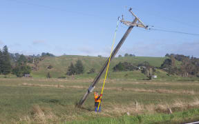 Lines workers right power poles on Wainui Road in Cheddar Valley.