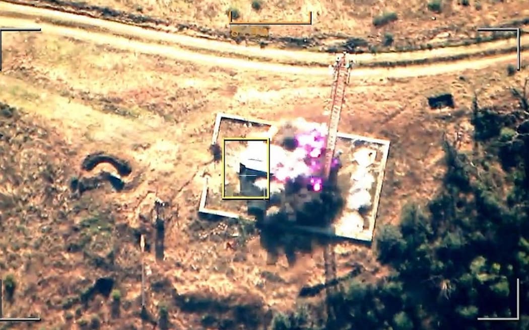 This grab taken from handout footage released by the Azerbaijani Defence Ministry on 19 September, 2023 shows an explosion in mountainous terrain, that Baku claims to be Azerbaijani forces 'destroying positions' used by Armenians in the Nagorno-Karabakh region. Azerbaijan said it had launched 'anti-terrorist operations' in the disputed region, over which the Caucasus arch-rivals fought a brief but brutal war in 2020.
