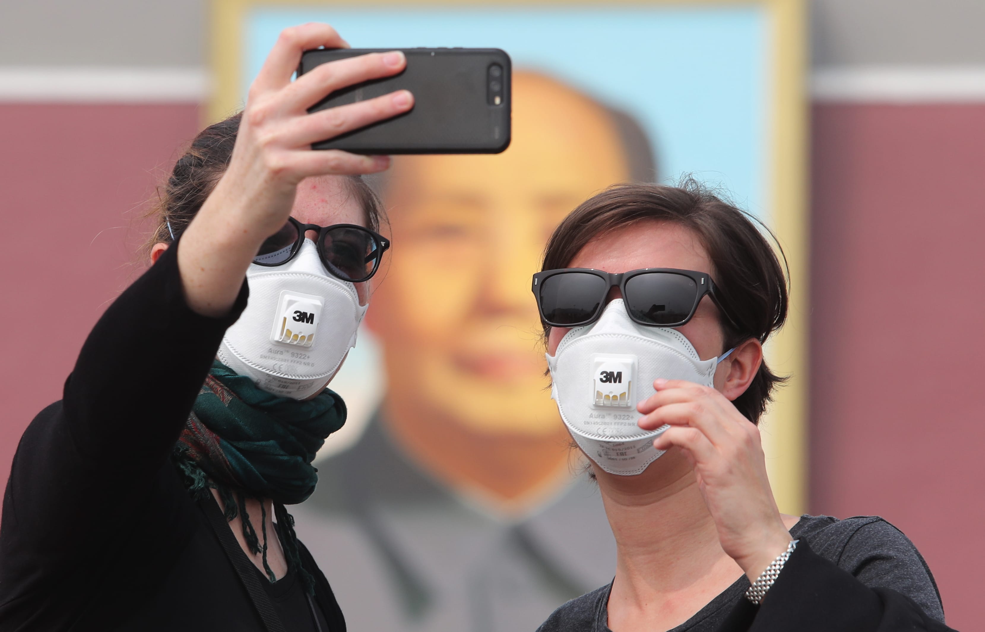 Foreign tourists wearing face masks against air pollution visit the Tian'anmen Square in heavy smog in, China.