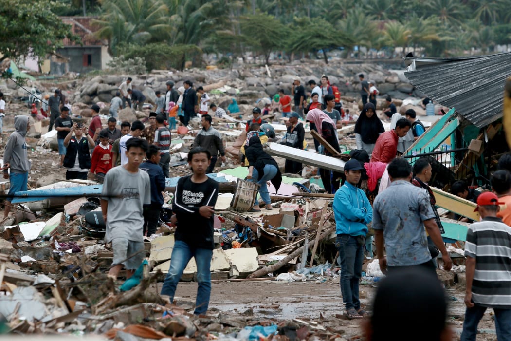 Rescuers and residents look for survivors along the coast in South Lampung on South Sumatra on 23 December, 2018, after the area was hit by a tsunami a day earlier.