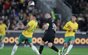 Chris Wood of New Zealand flicks a header towards goal against Australia.