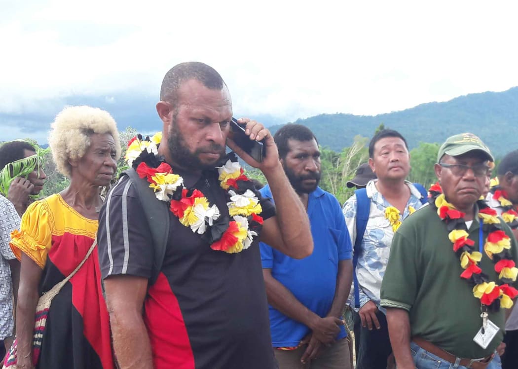 High school principal in Lumi district, John Tesa (with phone)
