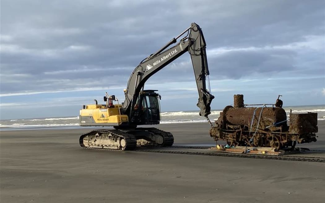 The Skunk locomotive being lifted out of the sand near Whanganui Port.