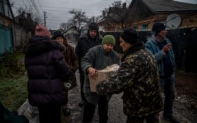 Locals receive humanitarian aid in Bakhmut, Donetsk region on December 8, 2022, amid the Russian invasion of Ukraine. (Photo by Ihor Tkachov / AFP)