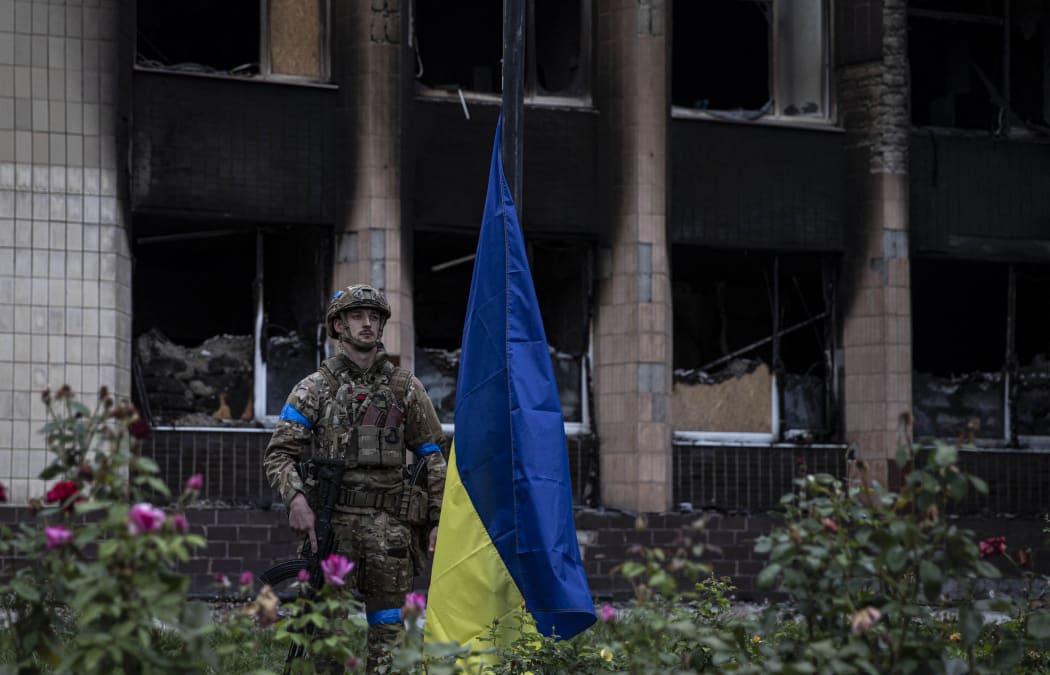 IZIUM, KHARKIV, UKRAINE - SEPTEMBER 14: Ukrainian soldiers stand guard as Ukrainian President Volodymyr Zelenskyy attends flag hoisting ceremony in Izium after the Ukrainian forces took control of the city from the Russian forces in Kharkiv, Ukraine on September 14, 2022. Metin AktaÅŸ / Anadolu Agency (Photo by Metin AktaÅŸ / ANADOLU AGENCY / Anadolu Agency via AFP)