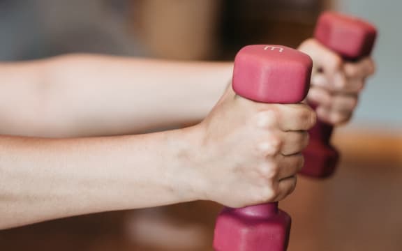 Person holding small hand weights