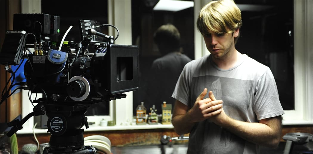 Gerard Johnstone stands near a film camera