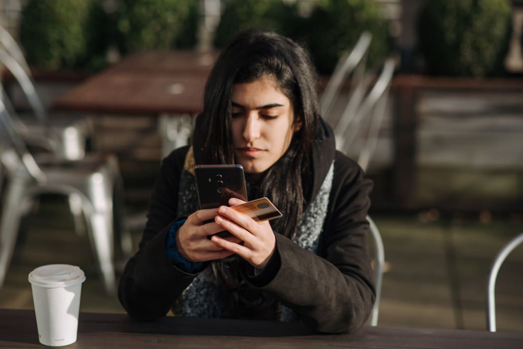 woman on phone with credit card