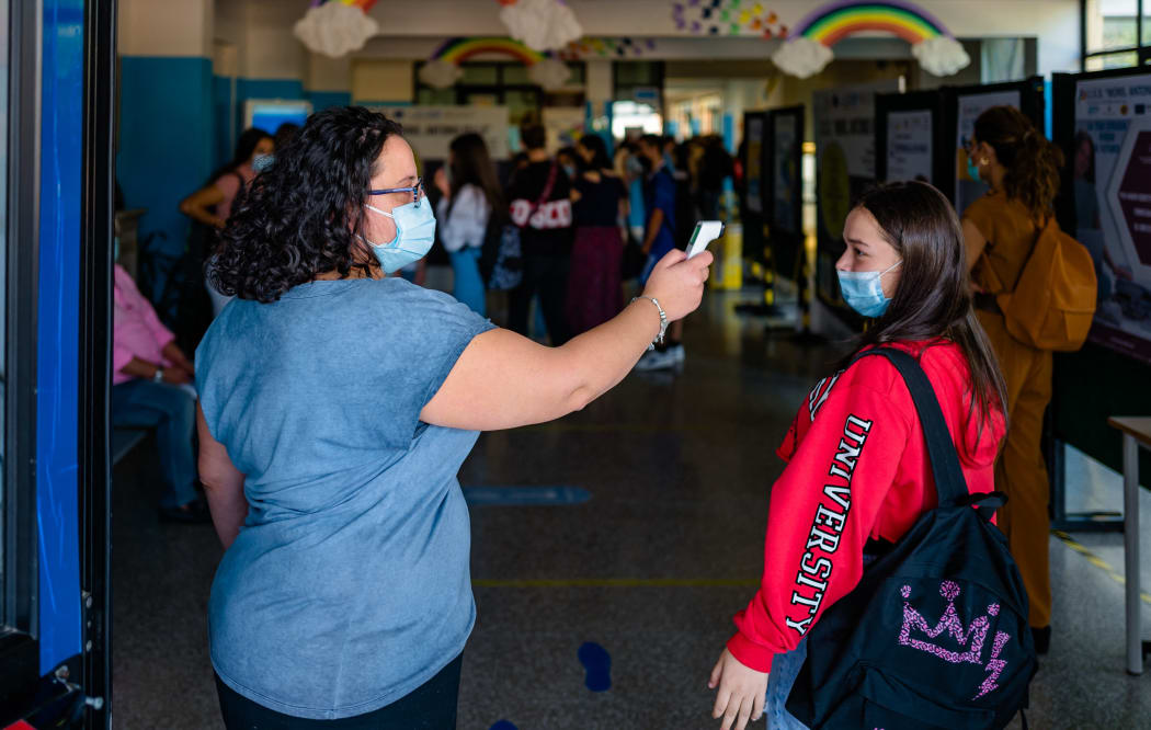 A scholastic collaborator of the Higher Institute Mons. Antonio Bello in Molfetta measures the temperature of students on the first day of school in Molfetta, Italy on 14 September 2021.