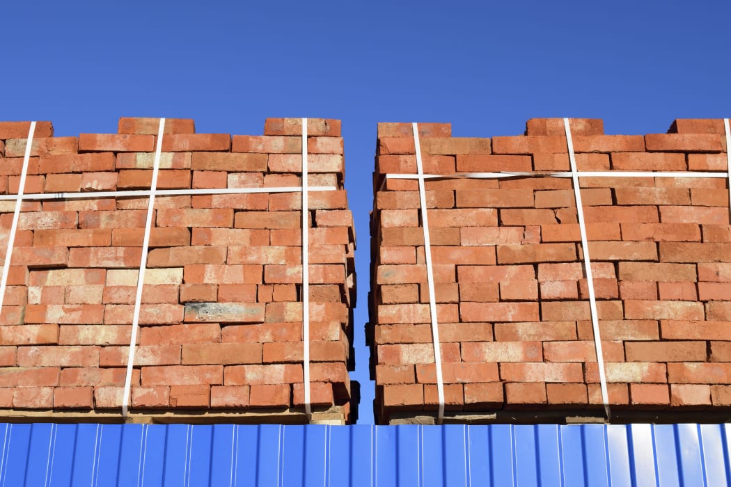 Red bricks stacked into cubes. Warehouse bricks. Storage brickworks products.