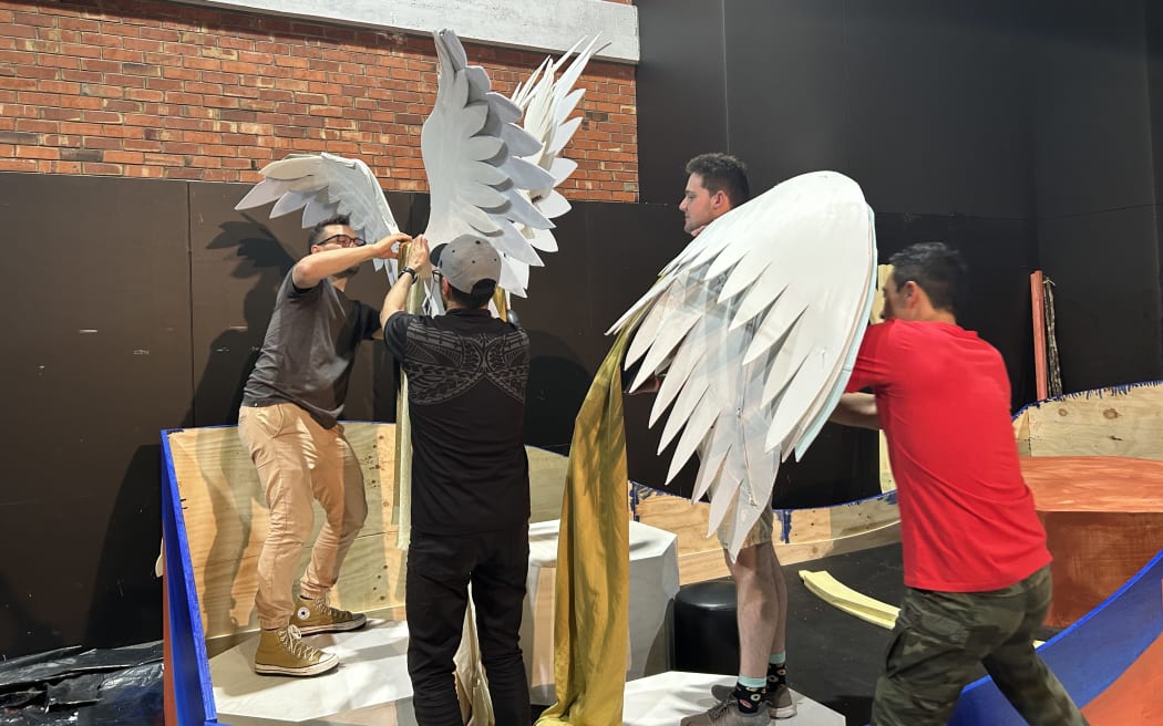 Picture depicts a group of people working to put wings up onto the nativity float.