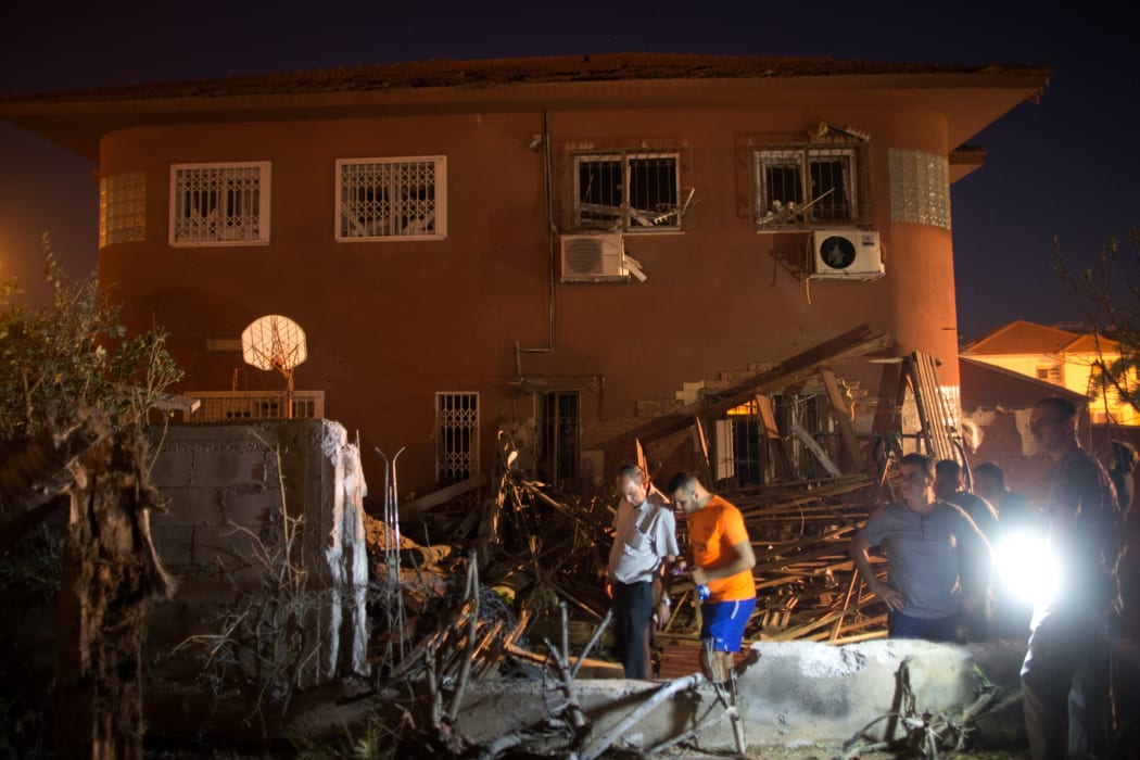 Israelis inspect damage to a house in Beer Sheva hit by a rocket fired from Gaza