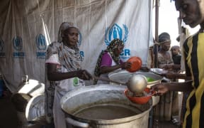Ethiopians, who fled the conflict in the Tigray region in northern Ethiopia, receive food at Hamdayit area after reaching Kassala State, Sudan on 14 December, 2020.