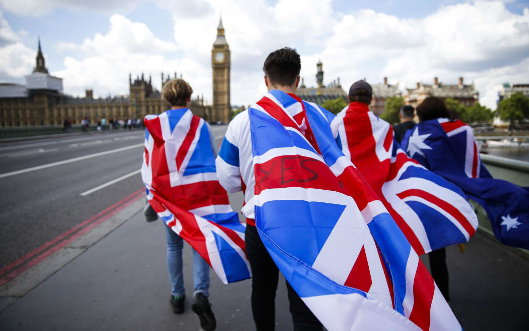 People walk over Westminster Bridge wrapped in Union flags.