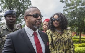 Former Malawi Vice President, Saulos Klaus Chilima (2nd L), who is now president for the United Transformation Movement (UTM) Party and who is the first petitioner in the Malawi Elecions Case, is accompanied by his wife Mary Chilima (R), waits to be screened at the Lilongwe High Court, where constitutional court judges will preside over the ruling on whether to annul the controversial vote that saw Malawi President Peter Mutharika re-elected in the May 2019 election, in Lilongwe on February 3, 2020. (Photo by AMOS GUMULIRA / AFP)