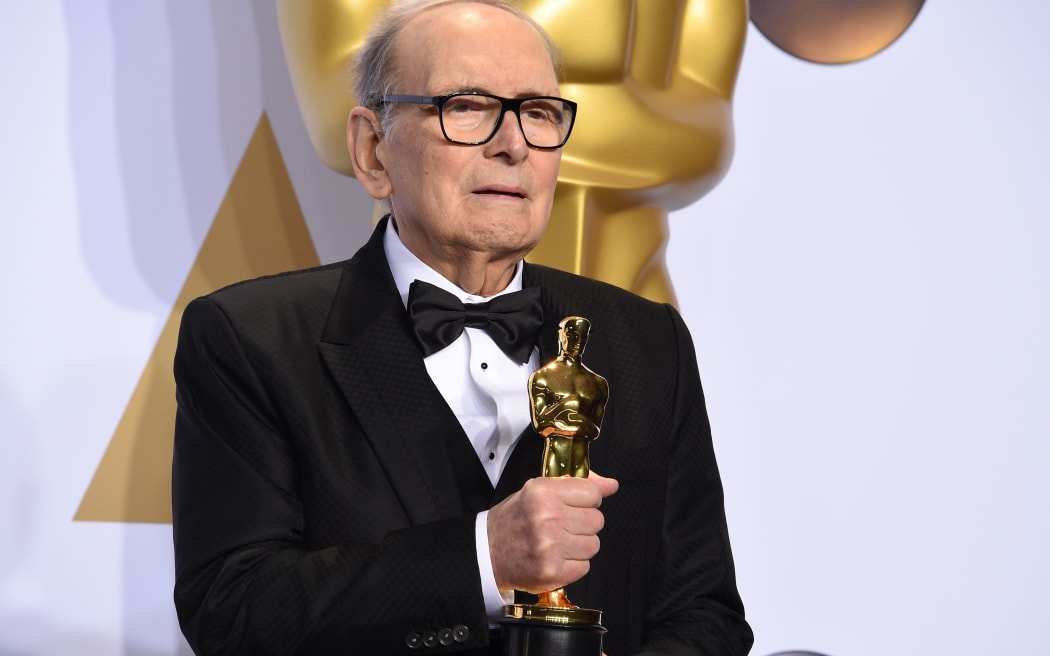 (FILES) In this file photo taken on February 28, 2016 Italian composer Ennio Morricone poses with the Oscar for Best Original Score, "The Hateful Eight," in the press room during the 88th Oscars in Hollywood.
